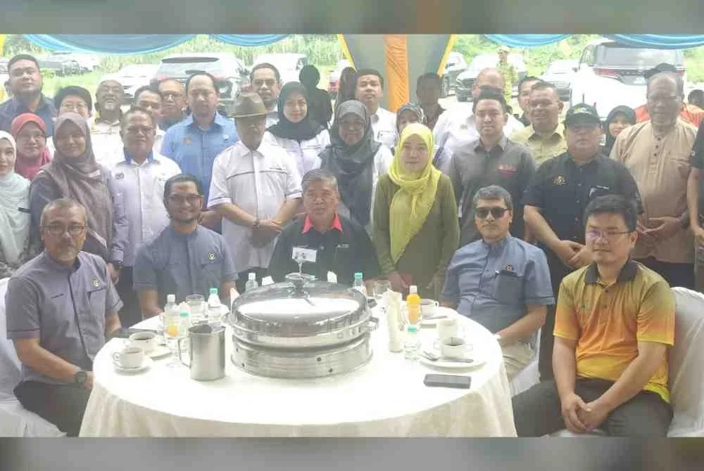 Mohamad (duduk, tengah) bergambar bersama tetamu dan peserta program semasa Program Peluncuran Tuaian Nanas di Projek Rintis Pintar Parlimen Kota Raja, Klang pada Jumaat.