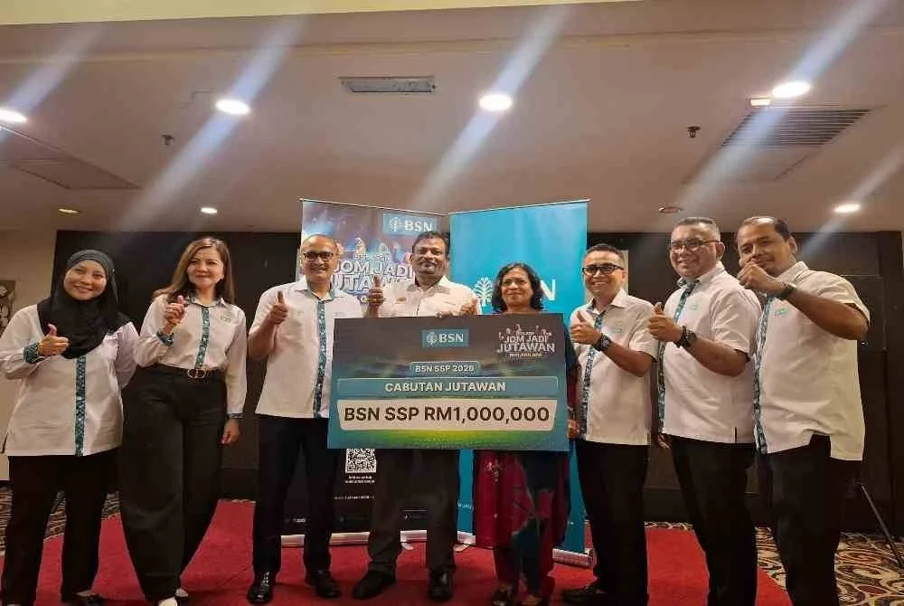 Munisuaran (empat dari kiri) ditemani isteri yang juga merupakan seorang guru, G Manjula, 55, semasa majlis penyerahan cek cura cabutan Jutawan Bank Simpanan Nasional (BSN) Sijil Simpanan Premium (SSP) bernilai RM1 juta.
