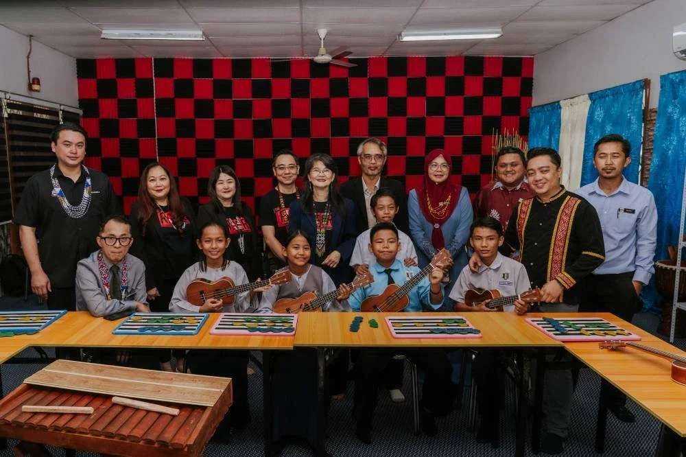 Josephine (belakang, tengah) dan Stefanus (depan, kanan) serta tetamu yang hadir bersama pelajar berkeperluan khas di Bilik Muzik Inklusif yang telah dinaik taraf.