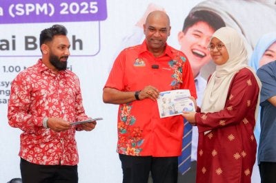 Ramanan menyampaikan sumbangan kepada salah seorang penerima sumbangan semasa Program Sumbangan Pelajar Cemerlang SPM 2025.
