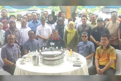 Mohamad (duduk, tengah) bergambar bersama tetamu dan peserta program semasa Program Peluncuran Tuaian Nanas di Projek Rintis Pintar Parlimen Kota Raja, Klang pada Jumaat.