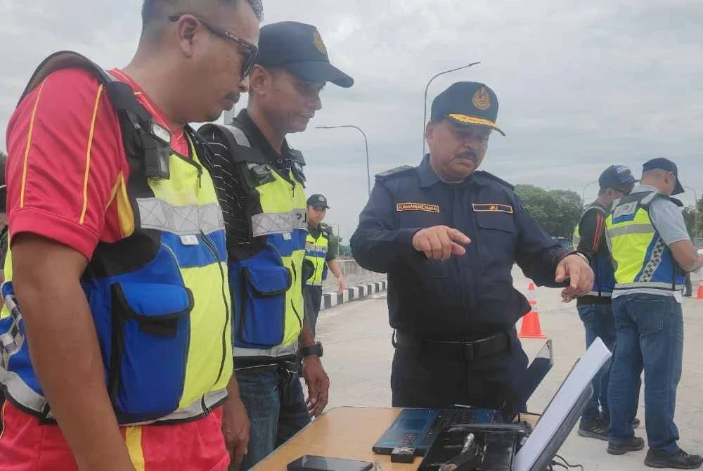 Ahmad Kamarunzaman (kanan) meninjau pelaksanaan Op Lebih Muatan yang dilaksanakan JPJ Selangor di R&R Dengkil pada Sabtu.