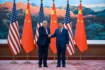 Presiden Amerika Syarikat, Donald Trump (kanan) berjabat tangan dengan Presiden China, Xi Jinping, di Dewan Besar Rakyat di Beijing. Foto: AFP