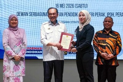 Anwar menyerahkan SST bagi Projek ‘Quick Win’ Tahun 2026 kepada salah seorang penerima Sesi Pertemuan dan Penyampaian SST kepada Kontraktor Kecil Bumiputera di Kompleks Pendidikan Negeri Perak, Ipoh pada Sabtu. - FOTO: Bernama
