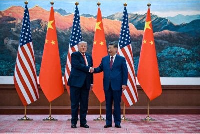 Trump (kanan) berjabat tangan dengan Jinping di Dewan Besar Rakyat, Beijing. - AFP