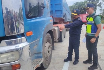 Ahmad Kamarunzaman (kiri) dalam Op Lebih Muatan yang dilaksanakan JPJ Selangor di R&R Dengkil pada Sabtu.