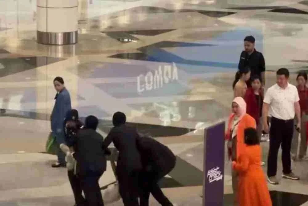 Tular video memaparkan seorang wanita bertindak agresif di Pintu Pelepasan Antarabangsa C, Terminal 1 Lapangan Terbang Antarabangsa Kuala Lumpur (KLIA).