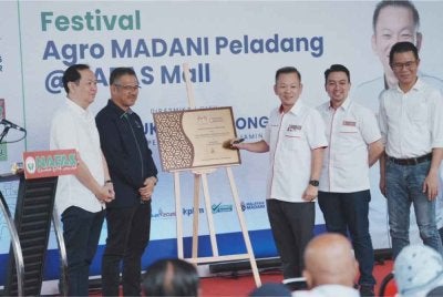 Chan Foong Hin (tengah) menandatangani plak selamat datang ke NAFAS Mall, Muar pada Festival Agro Madani Peladang yang dianjurkan pada 16 dan 17 Mei di Muar, Johor.