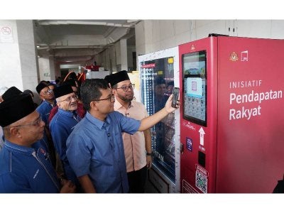 Menteri di Jabatan Perdana Menteri (Hal Ehwal Agama), Dr Zulkifli Hasan bersama Menteri Ekonomi, Akmal Nasrullah Mohd Nasir mencuba mesin layan diri pada majlis Perasmian Kerjasama Strategik Kementerian Ekonomi dan MAIWP Di Bawah Program Inisiatif Pendapatan Rakyat - Inisiatif Usahawan Makanan (IPR-INSAN) di Masjid Wilayah Persekutuan Kuala Lumpur pada Sabtu. -FOTO: ROSLI TALIB
