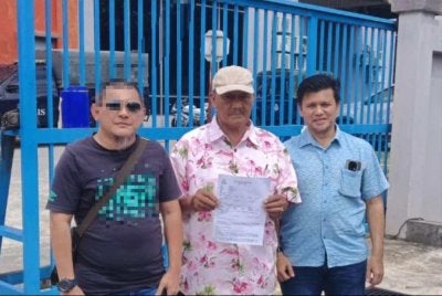 Daing Mohamad (tengah), Sharizan (kiri) dan Redzwan ketika membuat laporan polis di IPD Ampang pada Ahad.