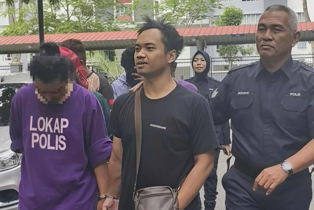 Muhammad Zuhairi (tengah) dibawa ke Mahkamah Majistret Seremban pada Isnin.