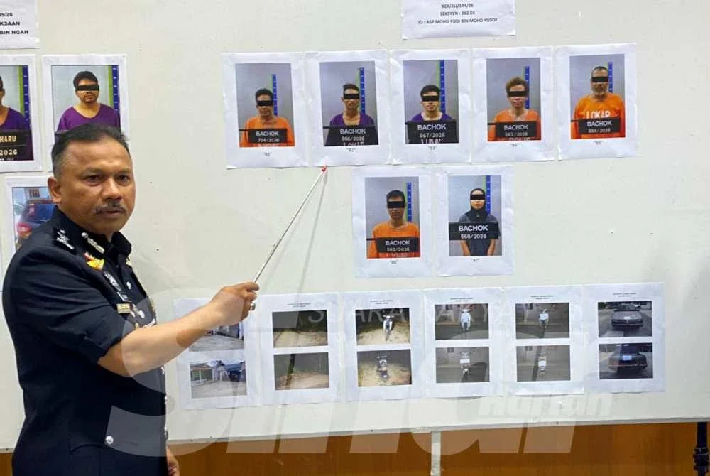 Mohd Yusoff menunjukkan gambar suspek yang ditahan bagi membantu siasatan.