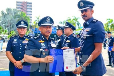 Mohd Yusoff (kiri) menyampaikan surat penghargaan kepada pegawai pada Perhimpunan Bulanan IPK Kelantan pada Isnin.