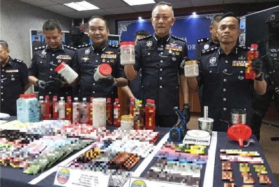 Chuan Huat (dua dari kanan) menunjukkan pelbagai jenis dadah yang dirampas daripada sindiket ketika sidang akhbar di IPK Johor pada Isnin.