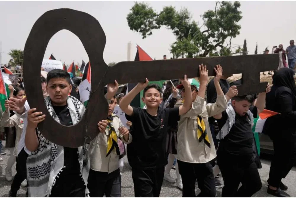 Kumpulan kanak-kanak Palestin berarak sambil membawa replika kunci gergasi sebagai simbol menuntut hak untuk kembali ke tanah air mereka. - Foto Agensi