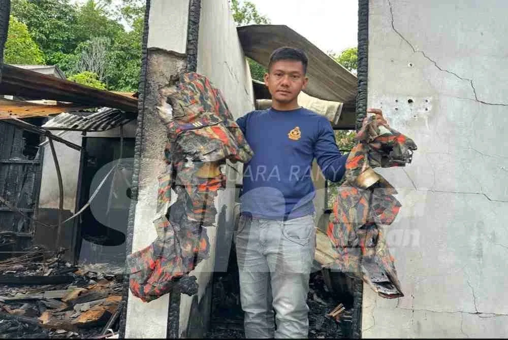 Mohd Alifudin menunjukkan sisa cebisan seragam celoreng yang terbakar.