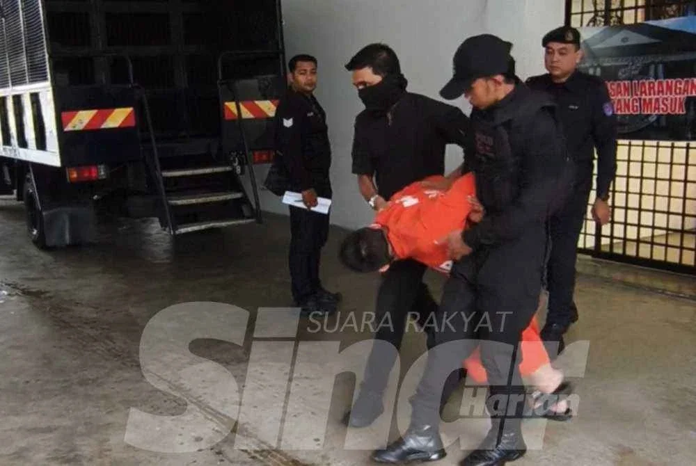 Ejen hartanah berusia 32 tahun tiba di mahkamah dengan berpakaian baju lokap sambil diiringi anggota polis.
