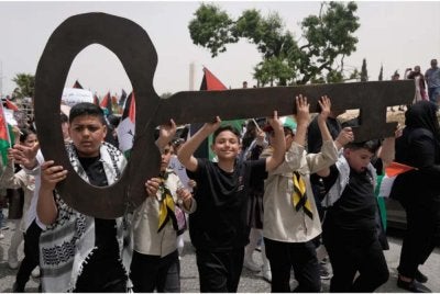 Kumpulan kanak-kanak Palestin berarak sambil membawa replika kunci gergasi sebagai simbol menuntut hak untuk kembali ke tanah air mereka. - Foto Agensi