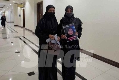 Noraidah yang memegang potret anaknya, Zara Qairina bersama kakak iparnya, Nur Shira hadir ke Mahkamah Kota Kinabalu.