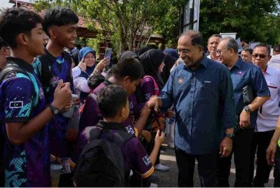 Zambry (tiga dari kanan) bersalaman dan beramah mesra bersama pelajar pada Majlis Peluncuran Kembara Pendidikan Tinggi@ Terengganu sempena Penyerahan Projek Kampung Angkat MADANI Universiti Malaysia Terengganu (UMT) di Sekolah Menengah Kebangsaan Menerong Ajil, pada Selasa. 