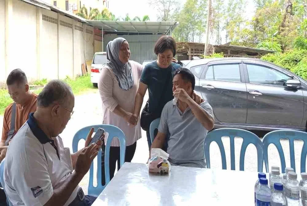 Norharizan (tiga dari kanan) bersama ibu dan bapa mendiang Wah Han Keong di rumah upacara pengebumian di Jalan Syed Zain, Kuala Terengganu pada Rabu.