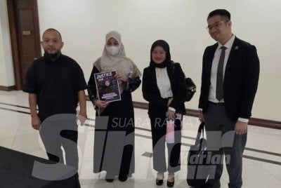Abu Bakar (kiri) ditemani Noraidah (dua dari kiri) dan diiringi peguam semasa tiba di Mahkamah Kota Kinabalu.