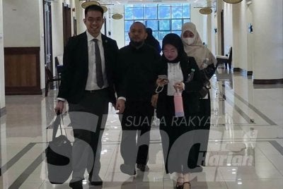 Abu Bakar (dua dari kiri) ketika tiba di Mahkamah Kota Kinabalu pada Rabu
