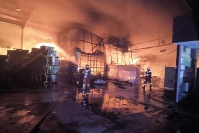 Anggota bomba bertungkus lumus memadam kebakaran kilang di Sungai Siput pada Selasa. - FOTO: JBPM Perak