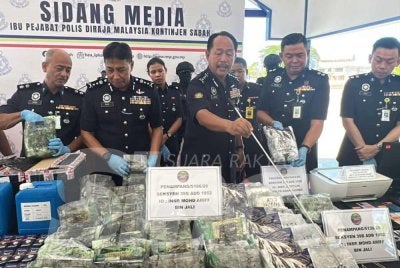 Jauteh (tengah) menunjukkan dadah yang dirampas Polis Sabah.