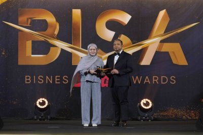 Mohd Al Iman menerima Anugerah Inovasi Integrasi Digital daripada Ketua Pegawai Eksekutif Sinar Harian, Farah Hussamuddin.