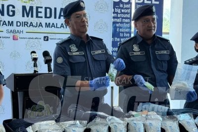 Ahmad Taufik (kiri) menunjukkan dadah yang berjaya dirampas JKDM Sabah