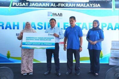 Rozaifee menyerahkan sumbangan kepada Nurul Atikah (kiri) mewakili Pusat Jagaan Al-Fikrah.