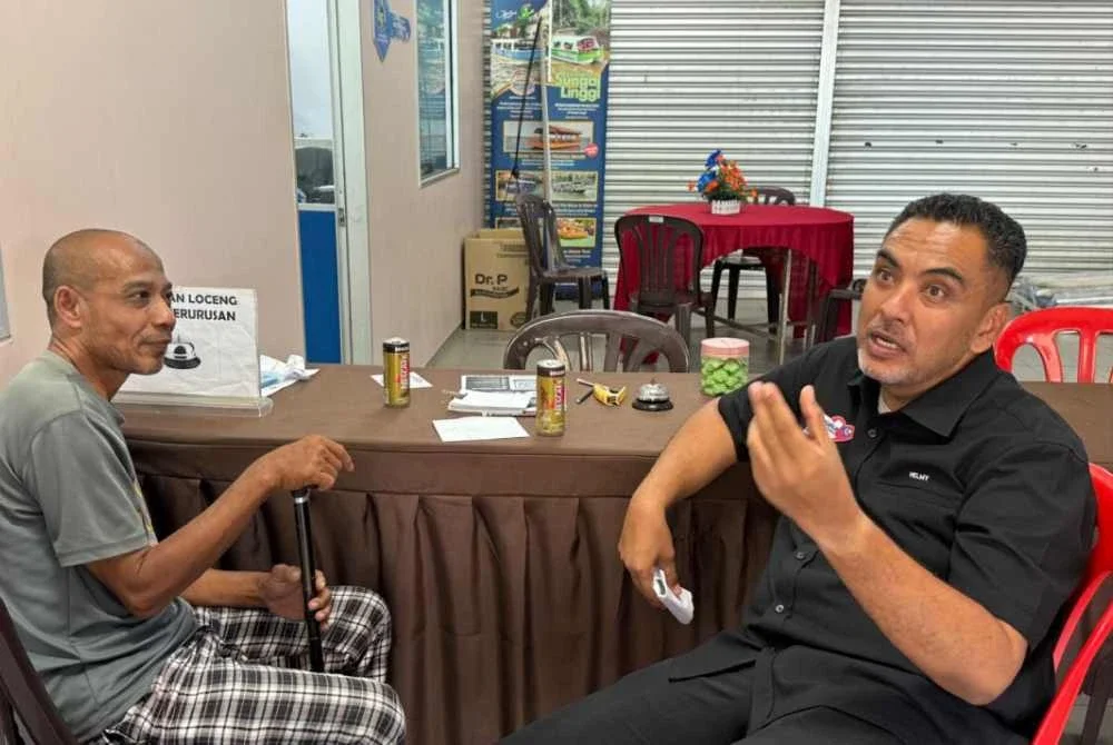 Azlan (kiri) bertemu Mohd Noor Helmy untuk meminta bantuan memulangkan wang ditemui kepada pemilik asal.