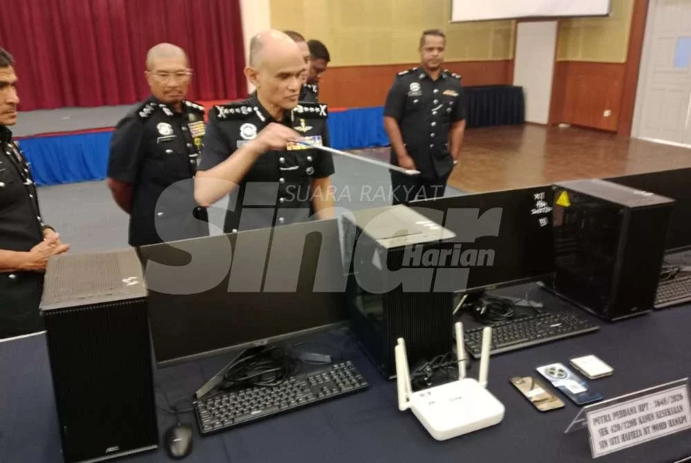 Shazeli (tengah) menunjukkan antara peralatan dirampas dalam serbuan dijalankan.