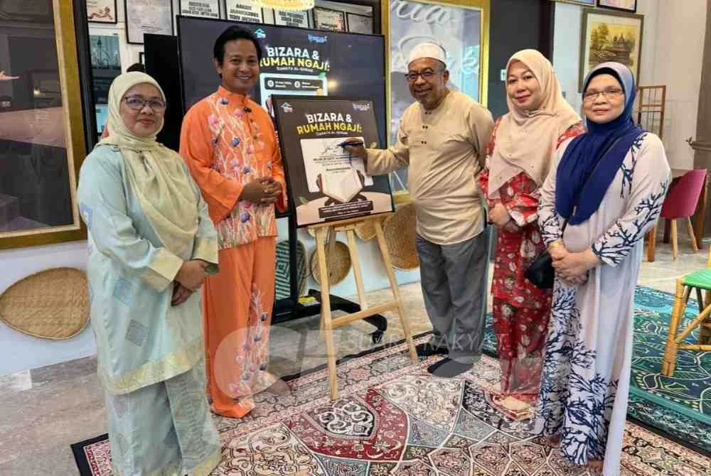 Wan Zakaria (dua dari kiri) yang turut mengiringi Adnan (tiga dari kanan) yang menandatangani plak kunjungan PRNNK ke Bizara.