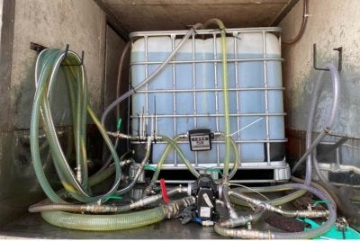 Sebuah tong IBC berkapasiti 1,000 liter yang penuh berisi cecair disyaki diesel disembunyikan dalam lori. Foto KPDN KEDAH