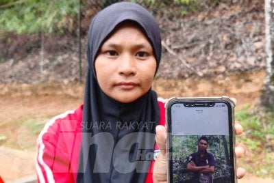 Nur Illyanis menunjukkan gambar abangnya, Mohamad Noor yang ditemukan maut akibat runtuhan tebing tanah setinggi dua meter dipercayai berlaku ketika aktiviti melombong emas di kawasan anak sungai Ladang Sawit Jerimbong di Jeli pada Rabu.Foto:SINAR HARIAN/HAZELEN LIANA KAMARUDIN