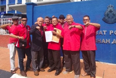 Kamarudin (tiga dari kiri) dan Ahmad Nawawi (tiga dari kanan) bergambar bersama ahli Veteran UMNO selepas membuat laporan di IPD Shah Alam pada Khamis.