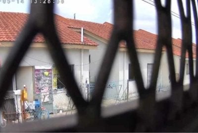 Tangkap layar rakaman video tular memaparkan seorang wanita meninggalkan seorang kanak-kanak di belakang rumah.