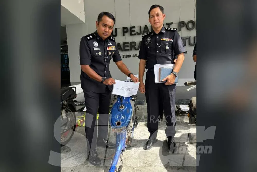 Jasni (kanan) menunjukkan rangka motosikal yang dirampas.
