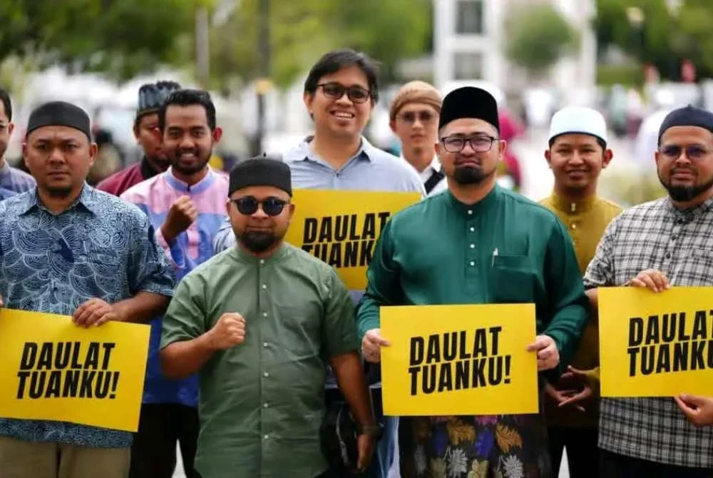 Mohamed Sukri (dua dari kanan) bersama Pemuda Pas Selangor menunjukkan poster 'Daulat Tuanku' di pekarangan Masjid Sultan Salahuddin Abdul Aziz Shah.