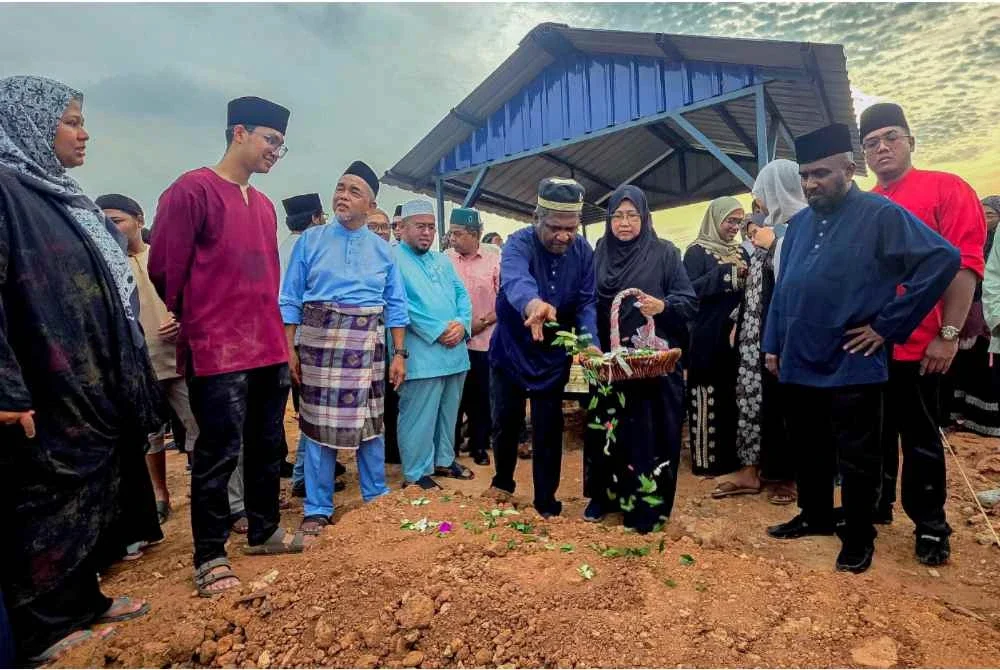 Akberdin (tengah) menabur bunga di pusara anaknya Allahyarham Adli Hakim Akberdin yang maut bersama dua lagi rakannya dalam kemalangan awal pagi tadi di Lebuhraya Karak menghala ke Kuala Lumpur selepas selesai pengkebumian di Tanah Perkuburan Islam Seksyen 21 Shah Alam. Foto Bernama