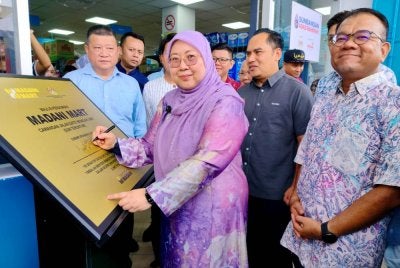 Fuziah menandatangani plak pelancaran rasmi Madani Mart Cawangan Jalan Dato Wong Ah Jang di sini pada Jumaat.