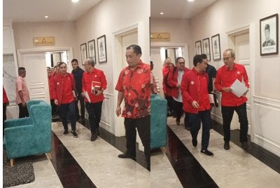 Onn Hafiz (kiri) keluar dari bilik mesyuarat UMNO Johor pada Jumaat.