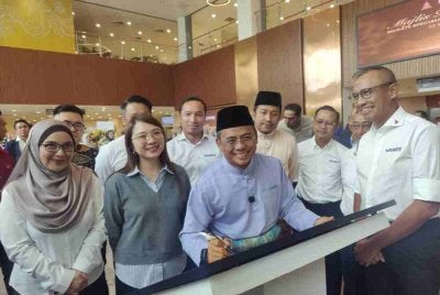 Amirudin menandatangani plak semasa Majlis Perasmian SSH Rawang pada Jumaat.