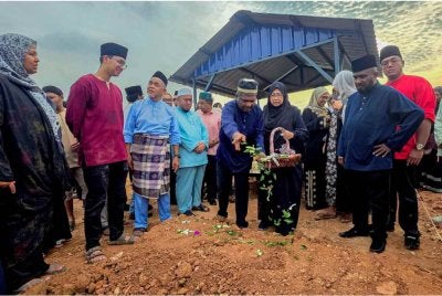 Akberdin (tengah) menabur bunga di pusara anaknya Allahyarham Adli Hakim Akberdin yang maut bersama dua lagi rakannya dalam kemalangan awal pagi tadi di Lebuhraya Karak menghala ke Kuala Lumpur selepas selesai pengkebumian di Tanah Perkuburan Islam Seksyen 21 Shah Alam. Foto Bernama