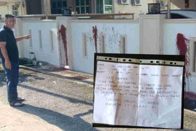 Dinding rumah mangsa yang disimbah cat merah selain nota ugutan turut ditanggalkan. 