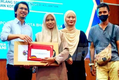 Muhammad Kamil (kiri) menyampaikan sumbangan kepada penerima pada Program Sumbangan Komputer Riba dan Bantuan Awal Ke Institusi Pengajian Tinggi kepada anak-anak eKasih Cemerlang SPM 2025 Negeri Kelantan, Jajahan Kota Bharu yang diadakan di Dewan Jubli Perak, Politeknik Kota Bharu di Kota Bharu pada Sabtu. Foto: SINAR HARIAN/HAZELEN LIANA KAMARUDIN