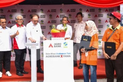 Anwar (tiga dari kiri) menyempurnakan Majlis Pelancaran Skim Usahawan Tani Agrobank x FAMA di Pasar Tani Taman Melawati, Kuala Lumpur dengan disaksikan Ahmad Badli Shah (dua dari kiri).