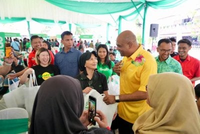 Ramanan (tiga dari kanan) beramah mesra bersama tetamu yang hadir pada Majlis Penghargaan Rakan Grab yang menghimpunkan rakan pemandu dan penghantar dari kawasan Parlimen Sungai Buloh pada Sabtu.